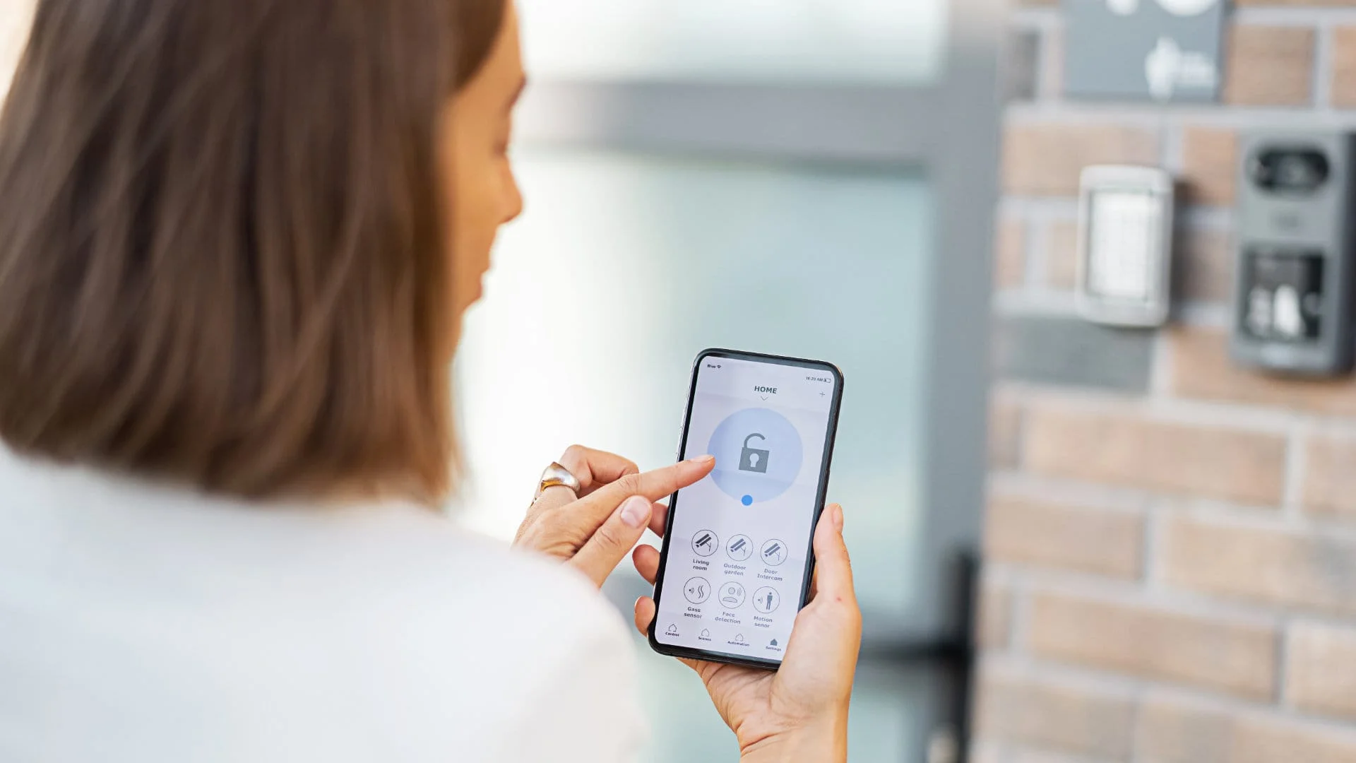 Donna gestisce il proprio allarme dallo smartphone fuori casa